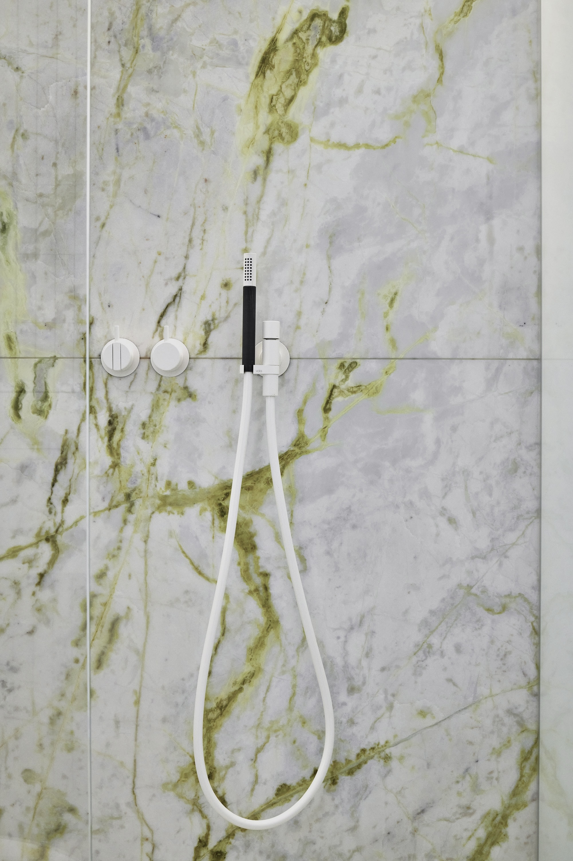 Luminous marble, yellow green marble veins, lime marble veins, powder room, white fixtures, Vola